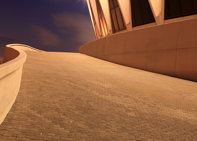 A night shot on a ramp leading to a coliseum.