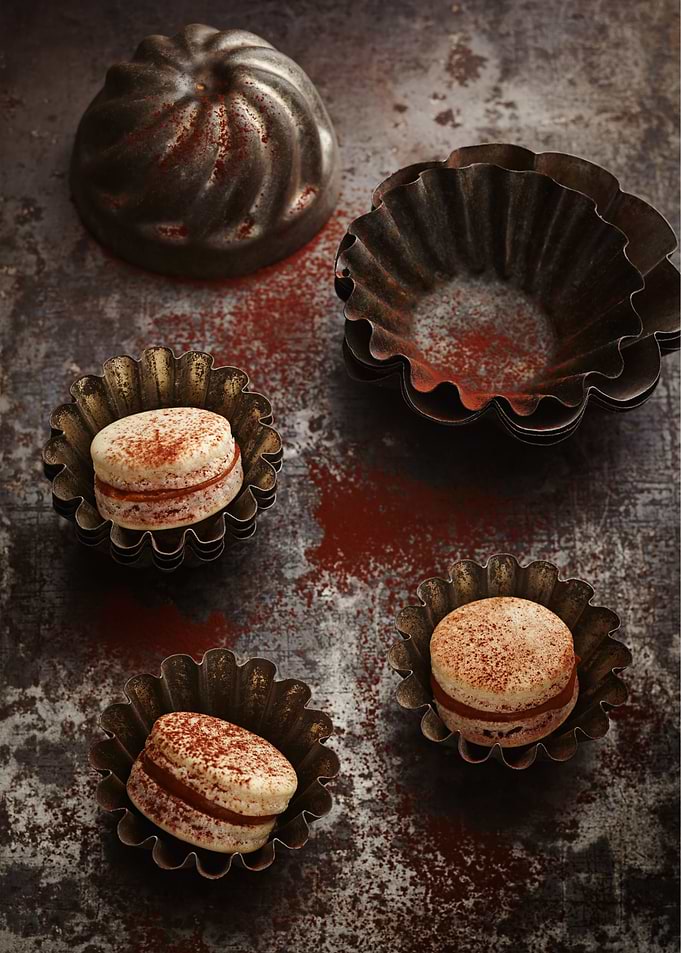 French macarons on rustic board in antique vintage baki ...