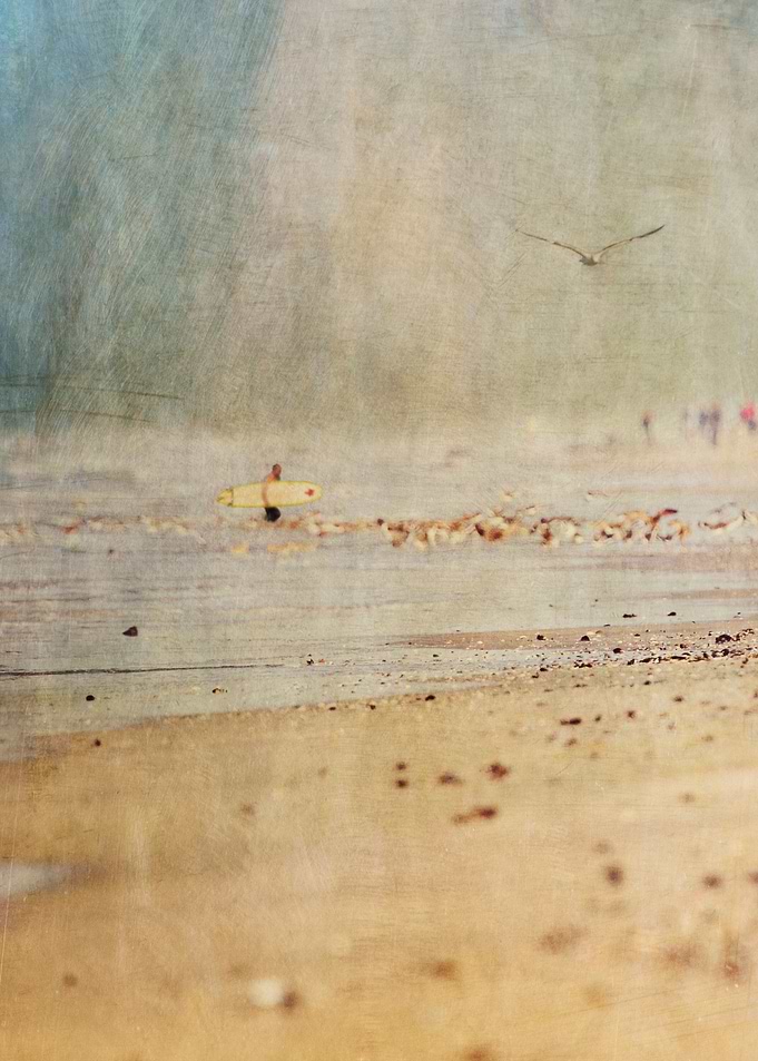 Lone surfer emerges from the Pacific Ocean in Huntingto ...