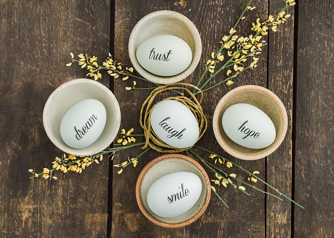 Eggs with handwritten messages in a basket with straw