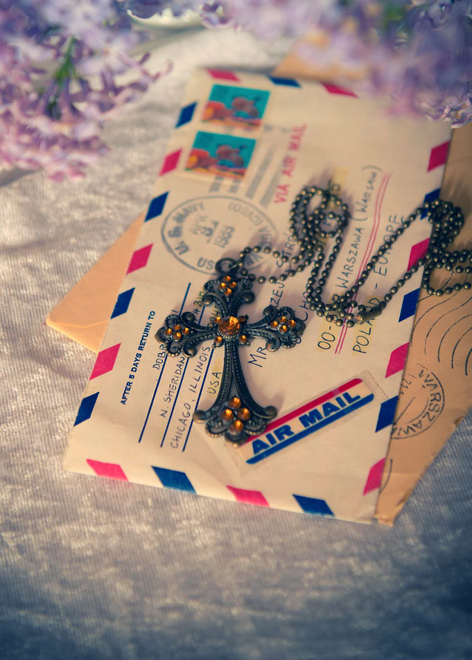 Still life with letters and cross pendant