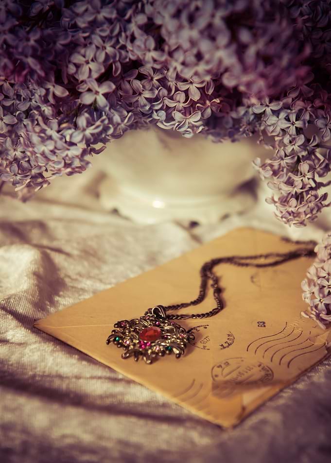 Still life with ornamented pendant and lilac flowers