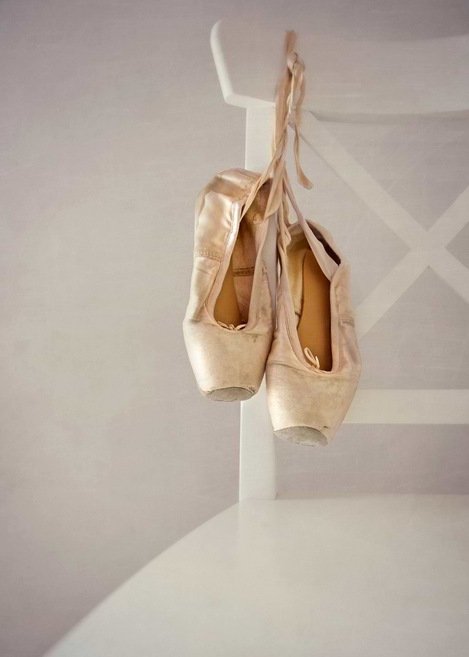 a pair of ballet shoes on a white chair