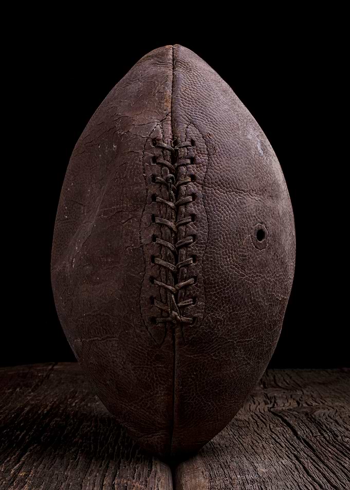 An old vintage leather football under dramatic lighting ...