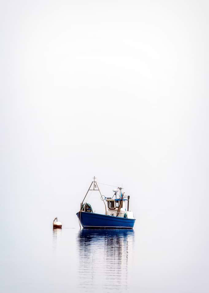 a fishing boat on a misty sea