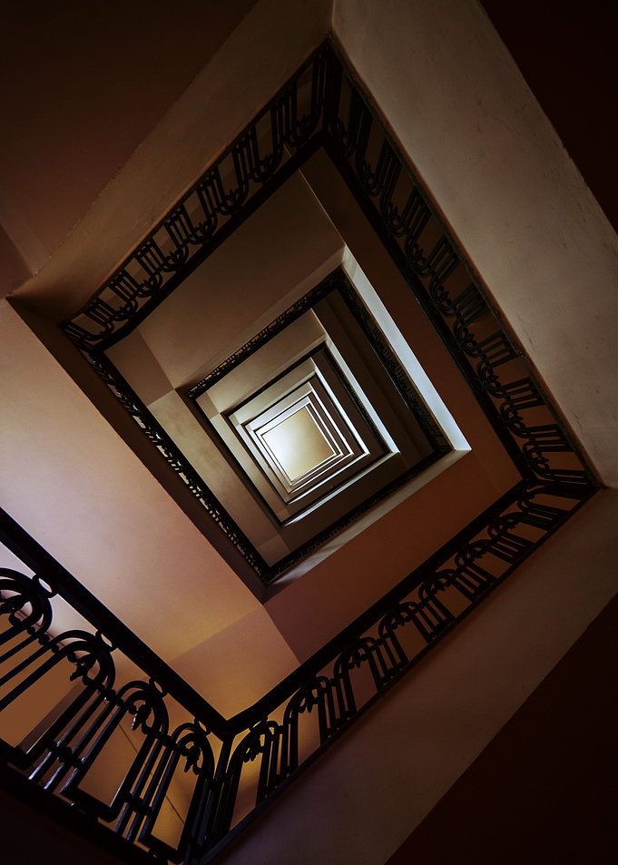 Square staircase in brown tones. View from the bottom