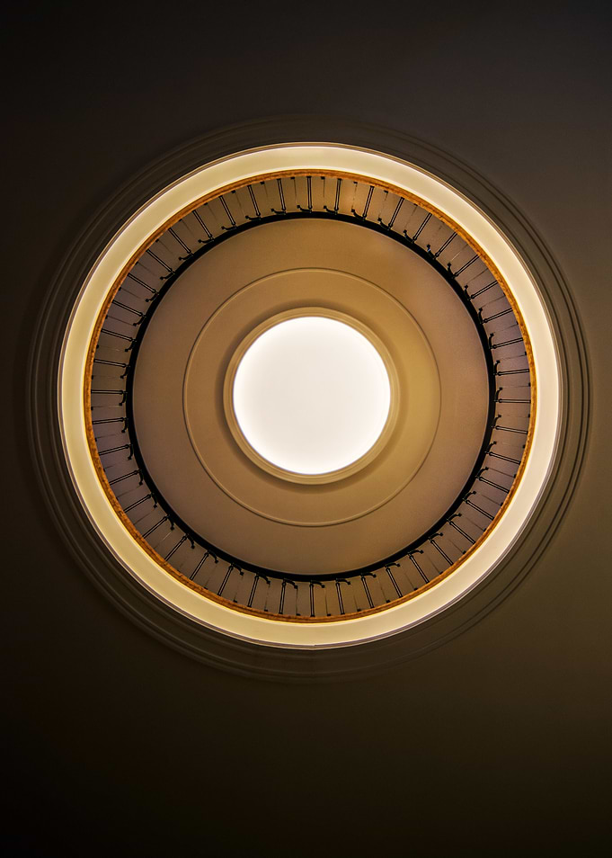 Round staircase with black handrail. View from the bott ...