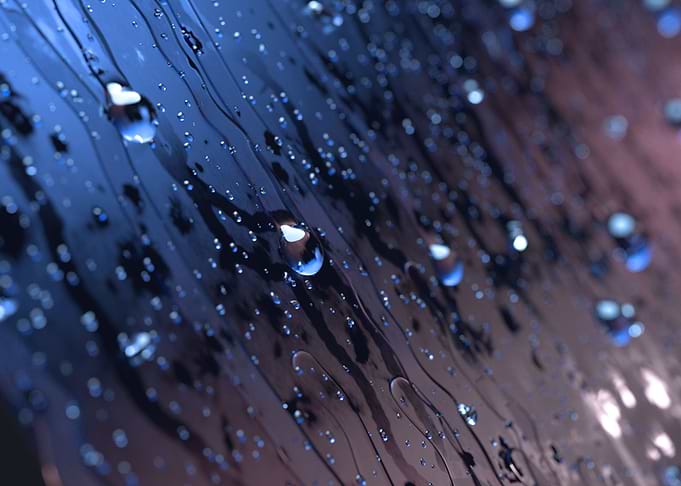 a closeup of rain drops on a glass.