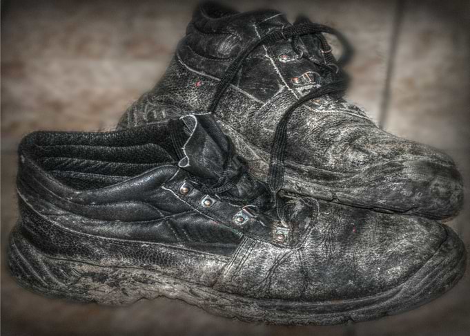 a hdr image of a pair of old work boots in mono