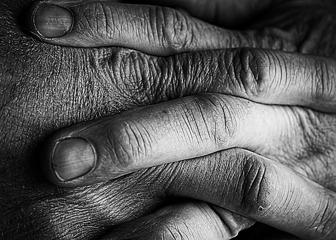 Strong hands clasped together in monochrome by Clare Be ...