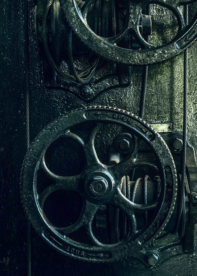 Detail of an old and heavy industrial machine with whee ...