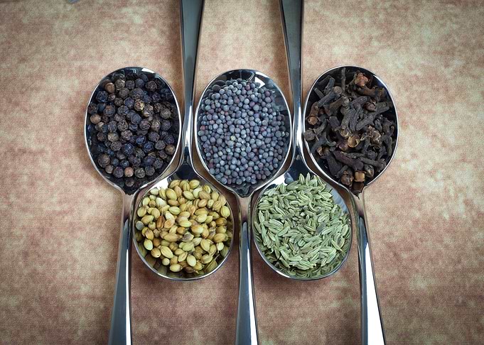 Spoons full of typical Indian spices used in making cur ...
