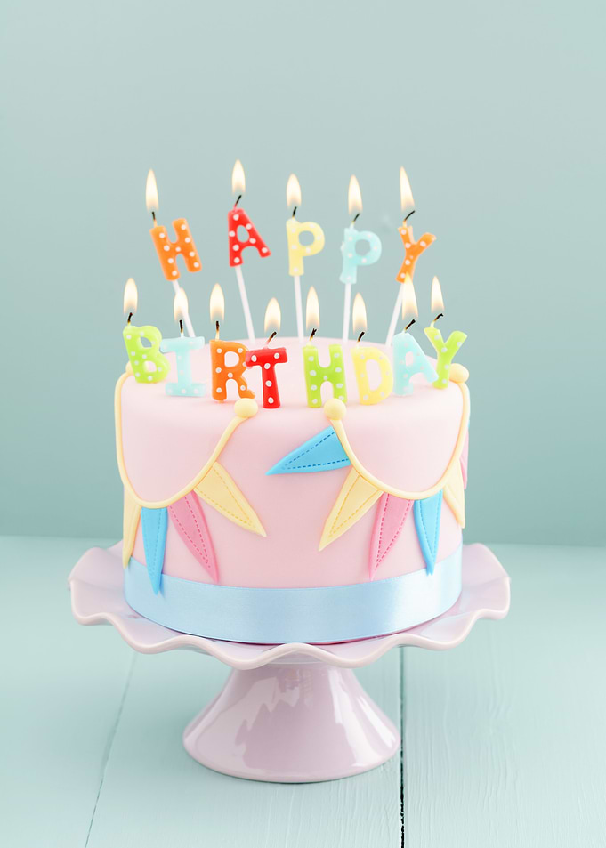 Fondant covered pastels coloured birthday cake with hap ...