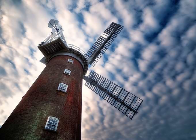 a windmill against a cloudy sky