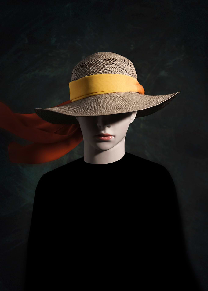 Portrait of a white manikin head wearing a straw hat wi ...