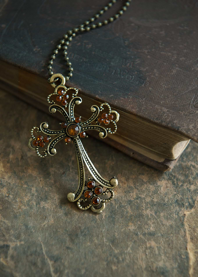 Cross pendant with orange gems and onld book
