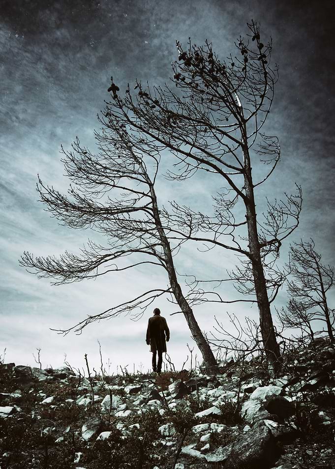 Silhouette on a men walking in a desolate lifeless fiel ...