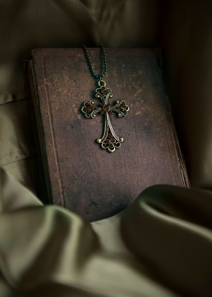 Ornamented cross pendant and old bible