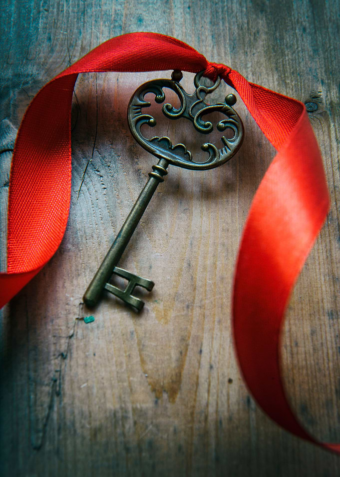 Nice ornamented key with red ribbon on wooden table