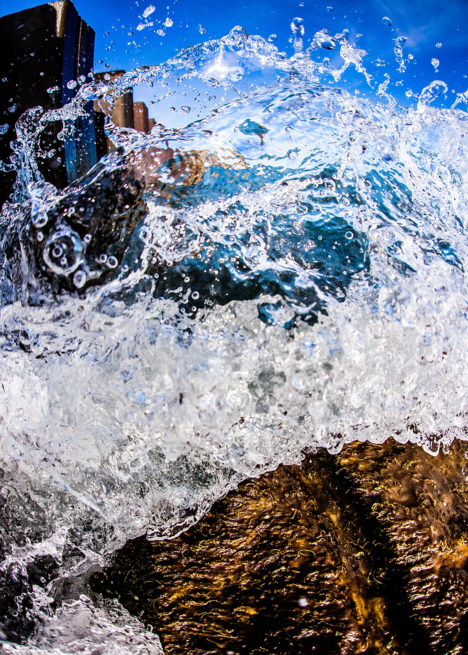 A wave crashes on a rock