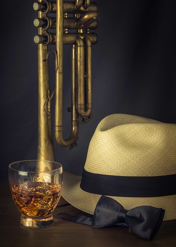 Vertically standing trumpet with a hat, drink and neck ...