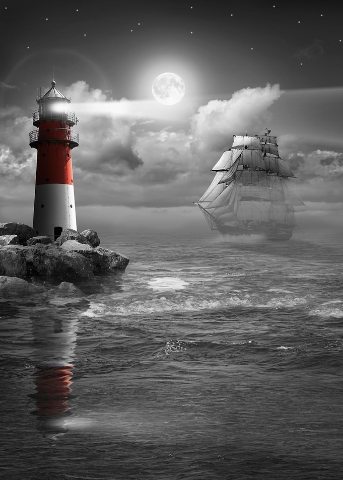 At night on the sea with sailing ship and lighthouse un ...