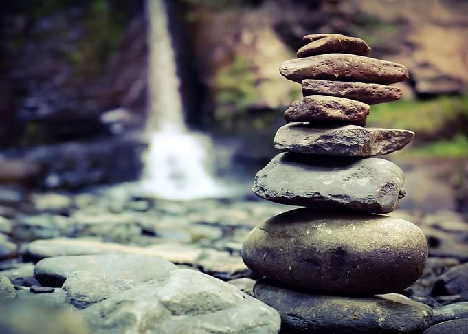 Cairn in front of a waterfall
