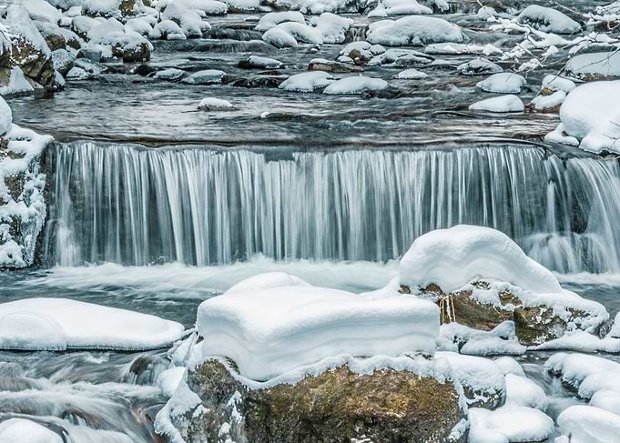 Small waterfall on freezing stream