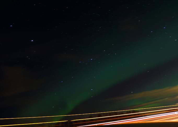 The aurora over top of a highway, got some taillights t ...