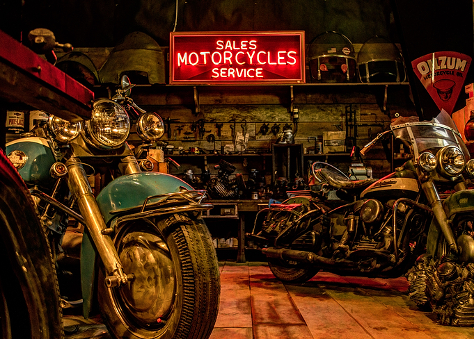 Motorcycles await service in a vintage repair shop