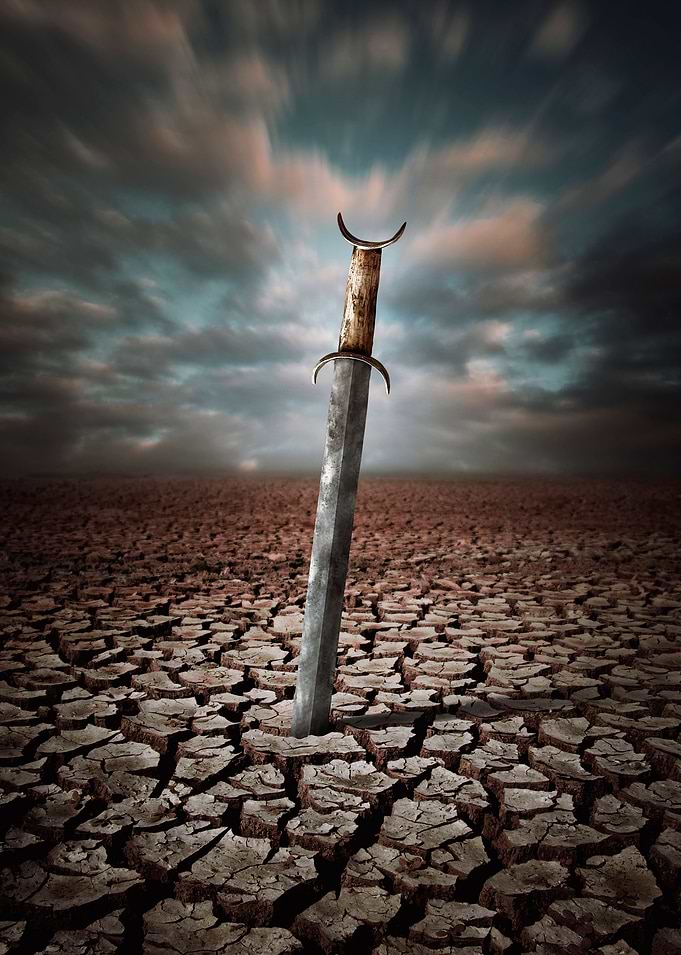 Ancient medieval sword stuck in the dry and cracked dir ...