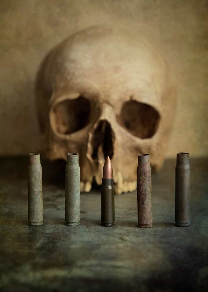 Skull and rusty bullets on metal surface