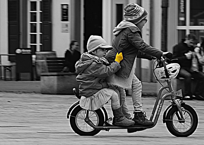 Two youngsters having fun on a scooter