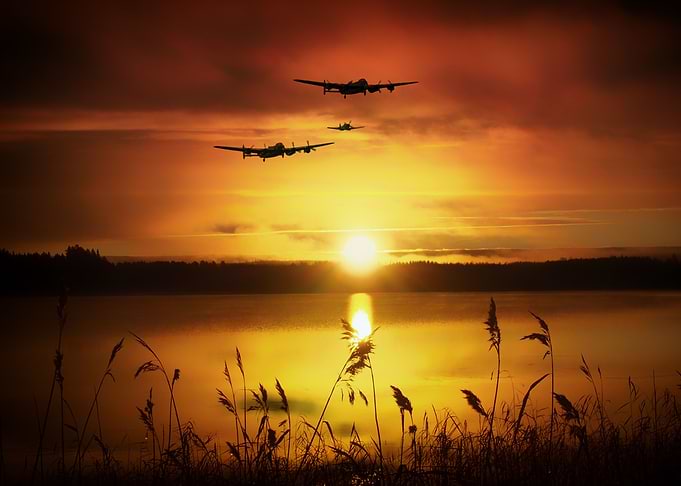Lancaster Bombers and Spitfire Warbirds over a lake at ...