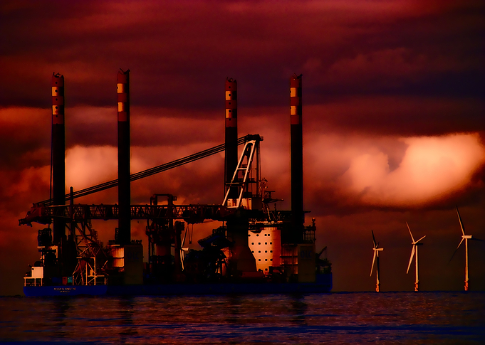 Oil rig passing at sunset