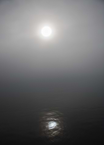 The sun peeking through the fog.