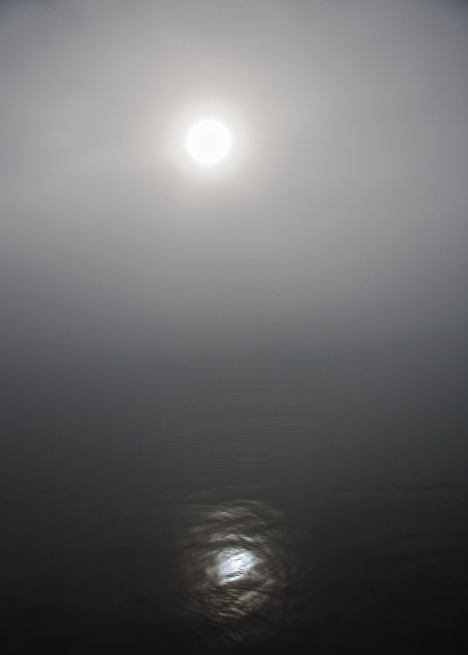 The sun peeking through the fog.