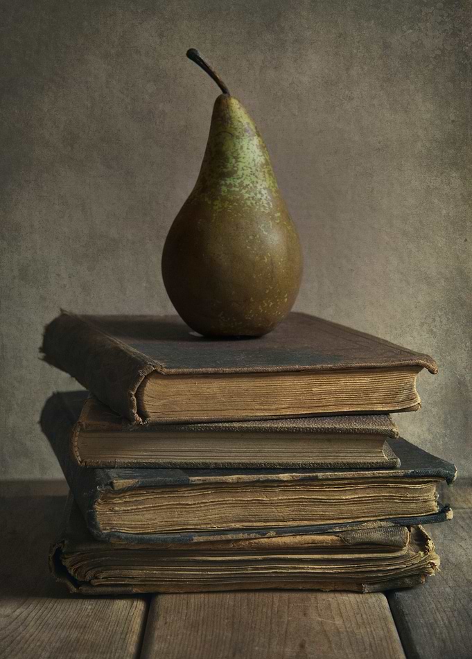 Still life with pear and old books