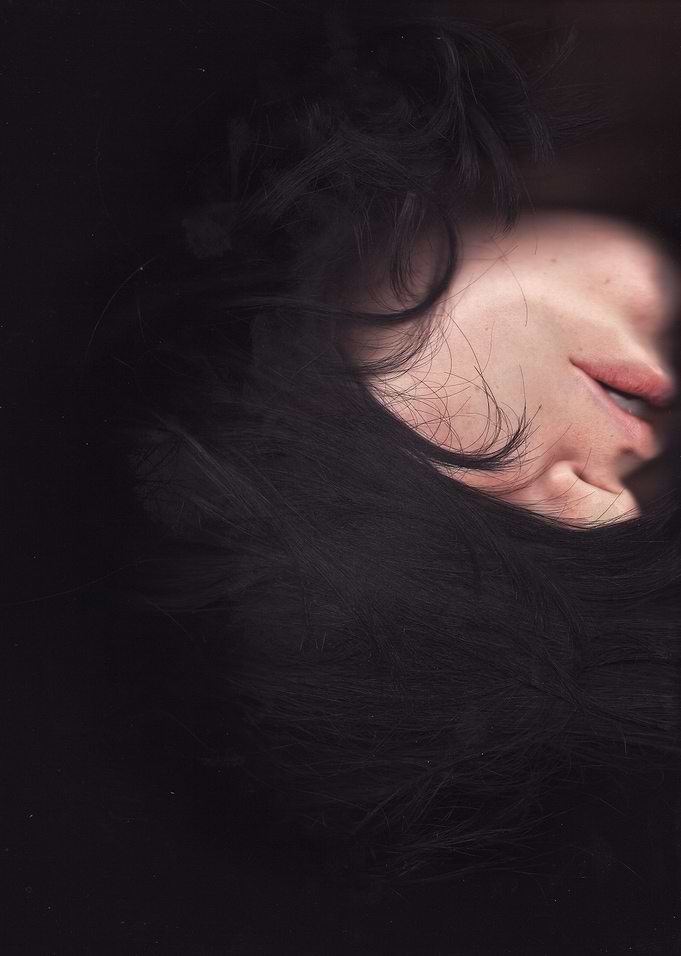 Feminine face partly covered by hair on the glass