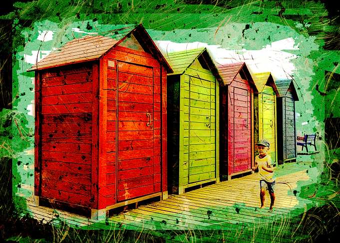 Boy running along beach sheds in Valencia, Spain