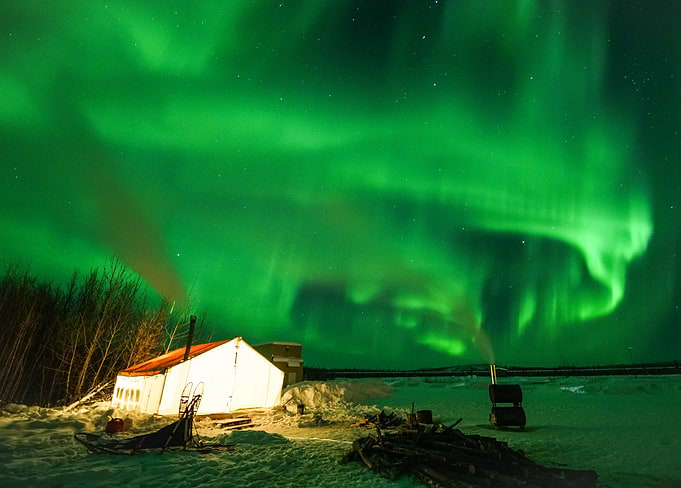 Dancing Aurora over Glowing Tent