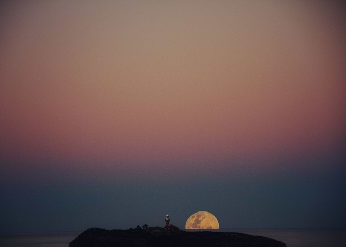 Moon against lighthouse