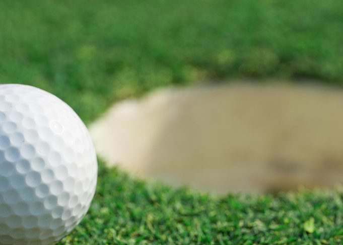 golf ball on lip of cup