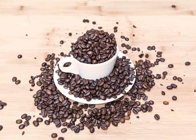 Coffee beans around cup