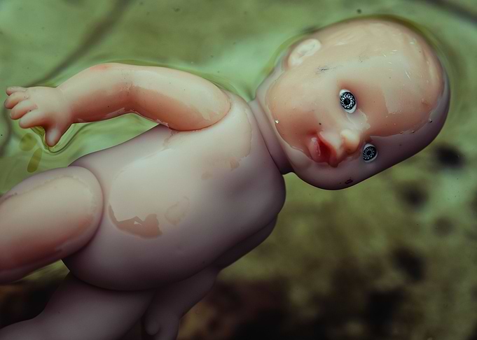 drowning weird child doll