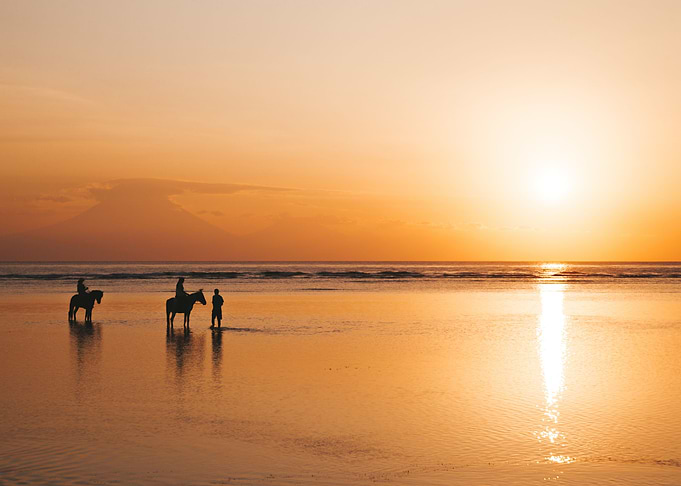 couple riding on the beach