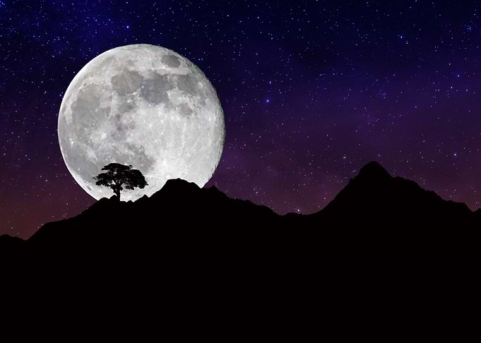 the moon behind the mounta