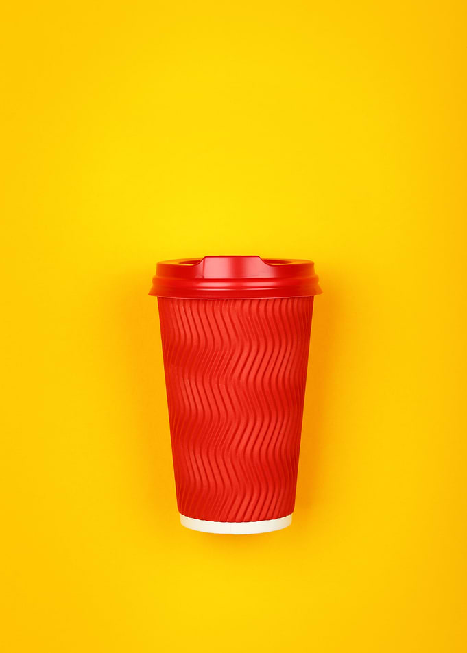 Red coffee cup on yellow