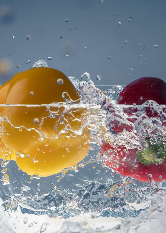 Peppers splashing in water