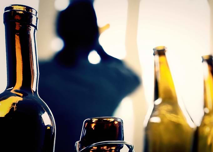 NM Drunk man bottles wine